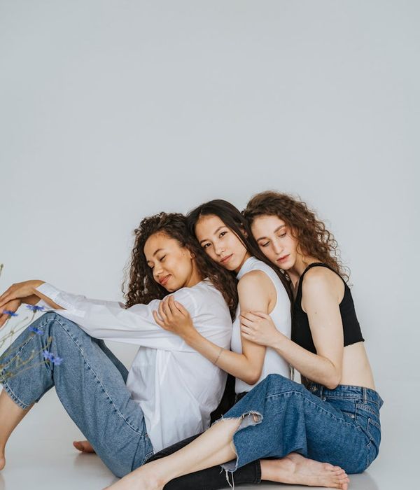 A diverse group of people sitting peacefully in a bright yoga studio.